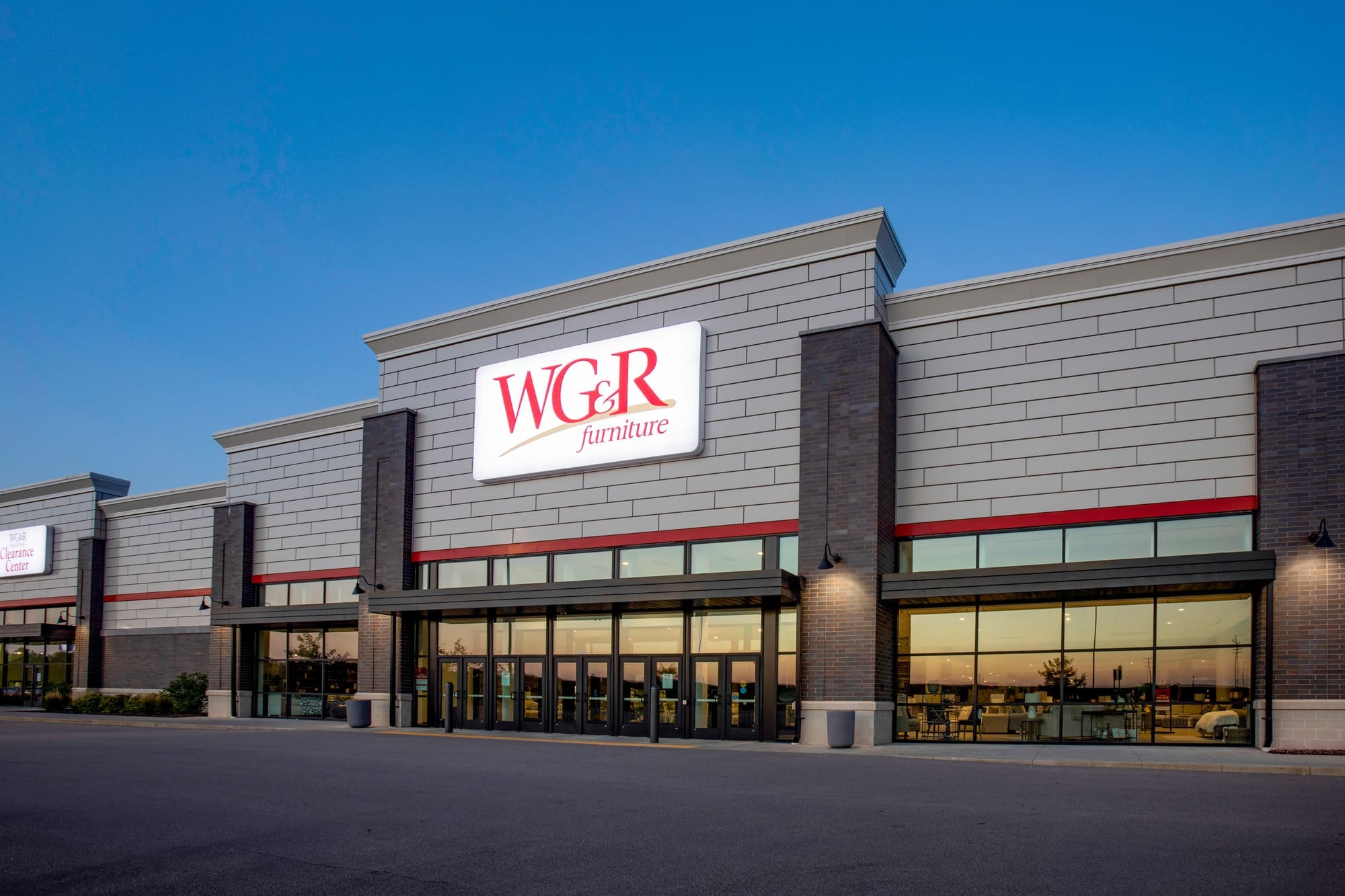 Exterior commercial real estate photo of modern WC&R Furniture store with glass entry doors, captured at dusk for property listing. Exterior commercial real estate photo of modern WC&R Furniture store with glass entry doors, captured at dusk for property listing.
