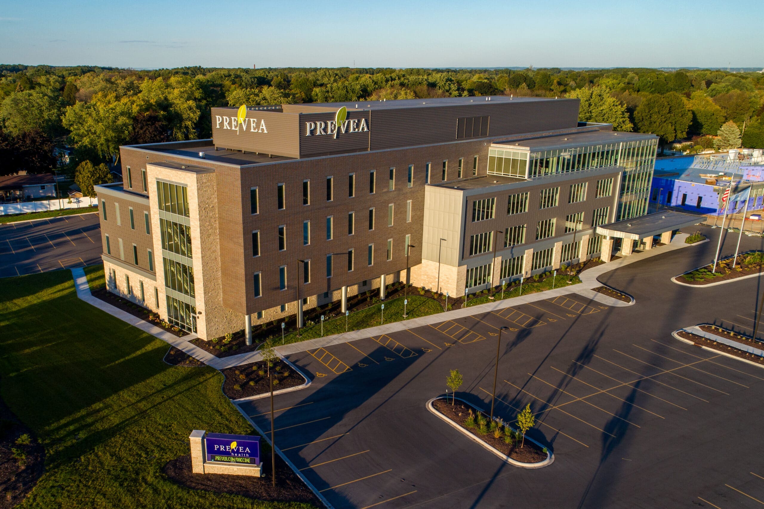 Commercial property: modern multi-story medical office with Prevea signage, ample parking, and landscaped green borders.