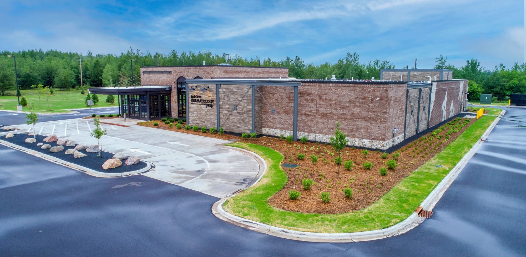 Modern commercial property with brick exterior, landscaped grounds, ample parking, mature trees, and inviting curb appeal.