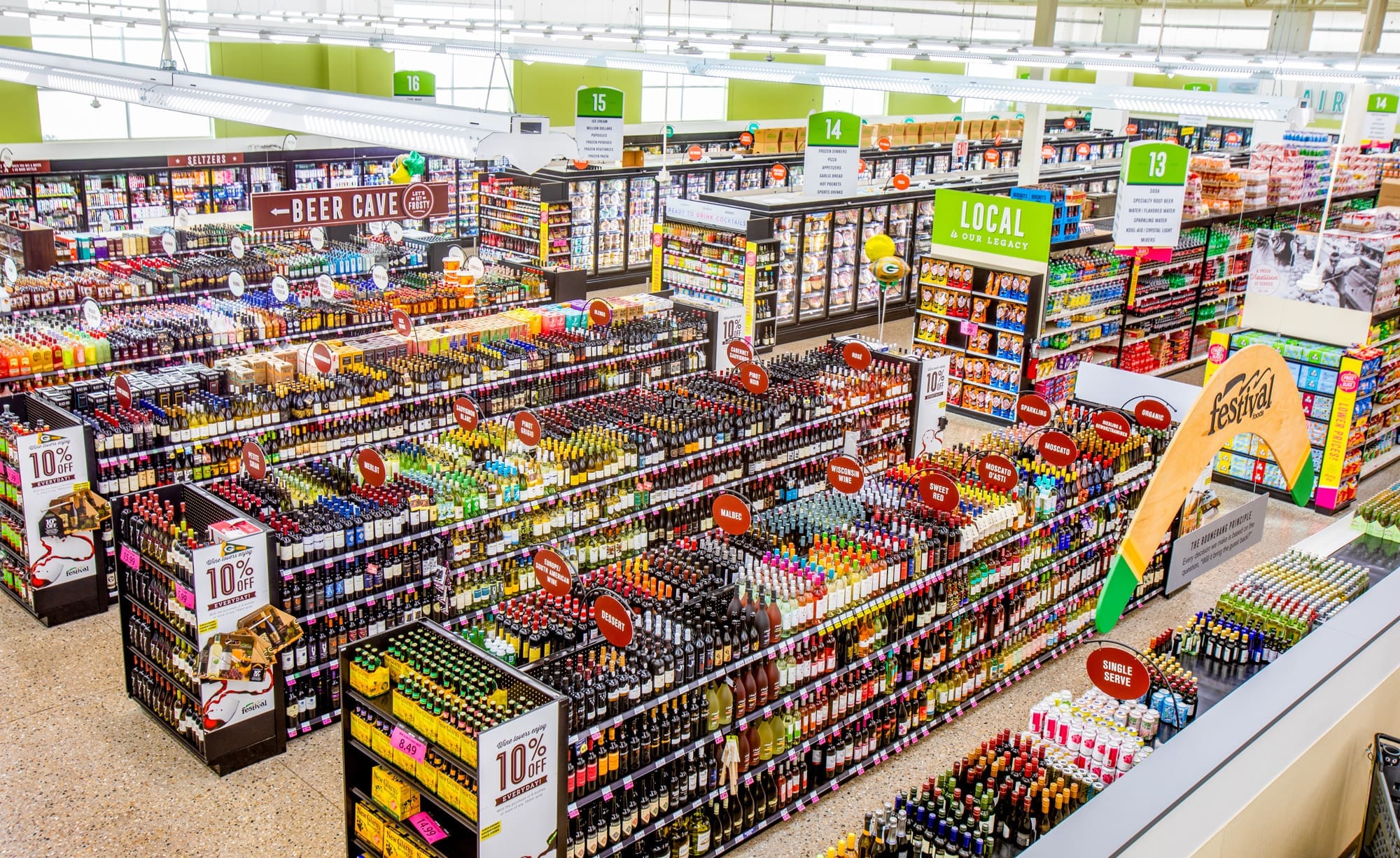 Commercial real estate photo: spacious supermarket liquor section, well-lit aisles, organized shelves, clear signage and product displays.