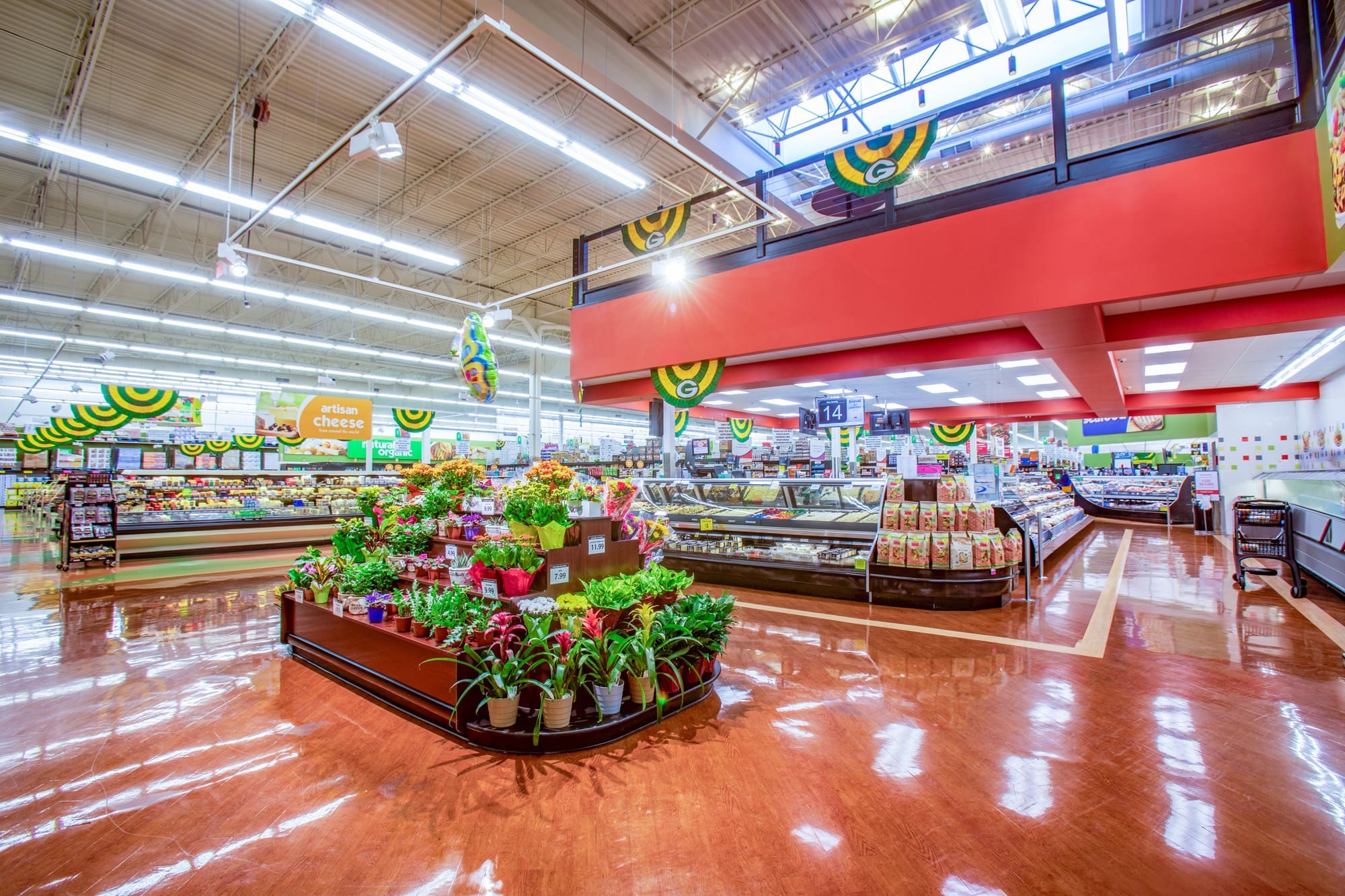 Commercial property interior featuring bright lighting, potted plants, and organized grocery sections ideal for retail real estate listings.