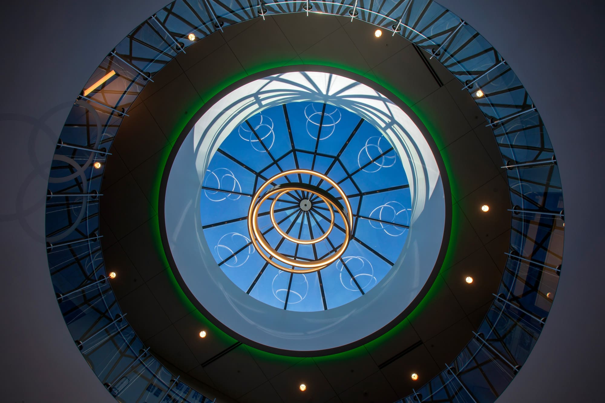 Modern commercial property skylight with circular glass ceiling, geometric metal framework, and sky views, ideal for real estate listings.